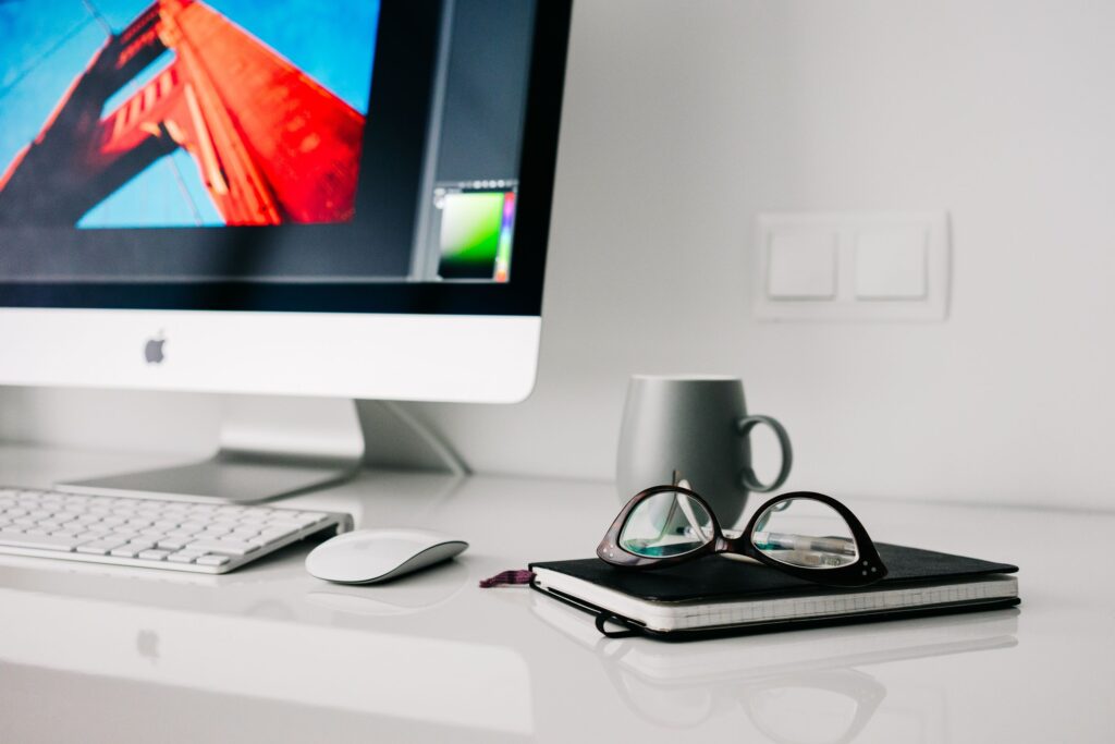 Home office desk with a computer and notebook for planning how to start a business