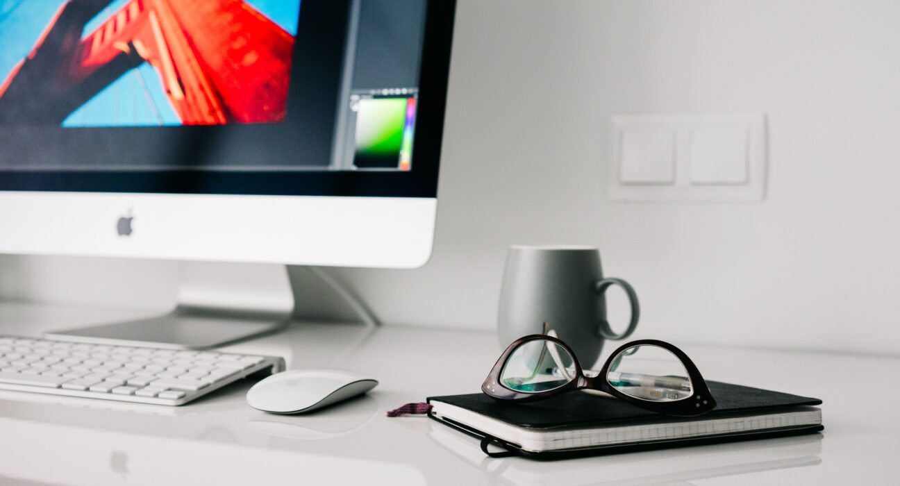 Home office desk with a computer and notebook for planning how to start a business