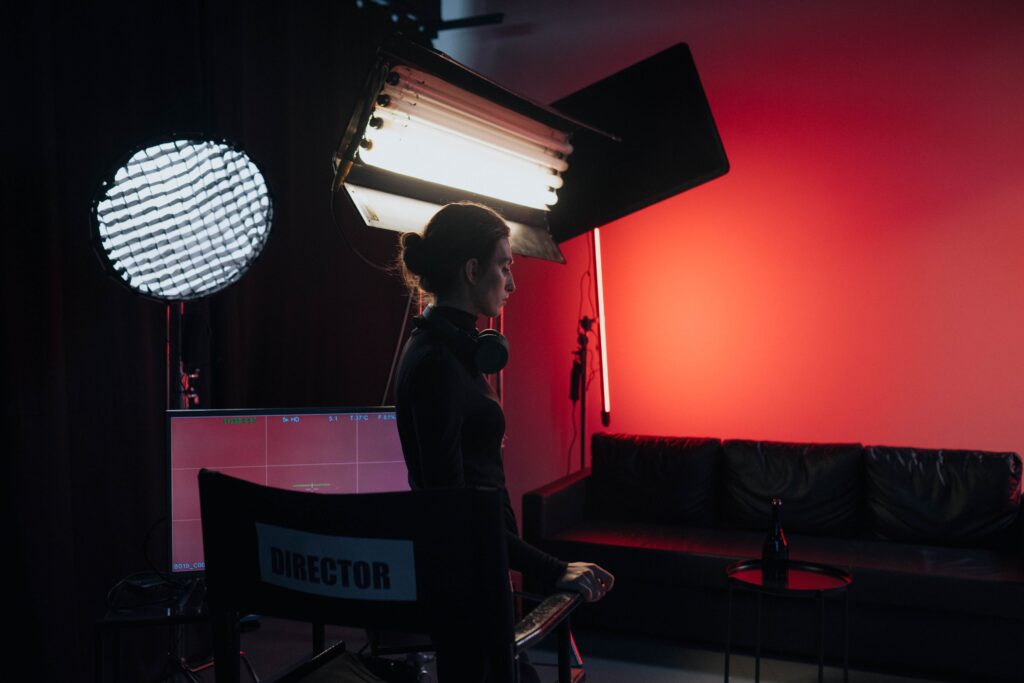 A film director standing in a studio in front of a director's chair, evoking the career behind Rob Reiner net worth