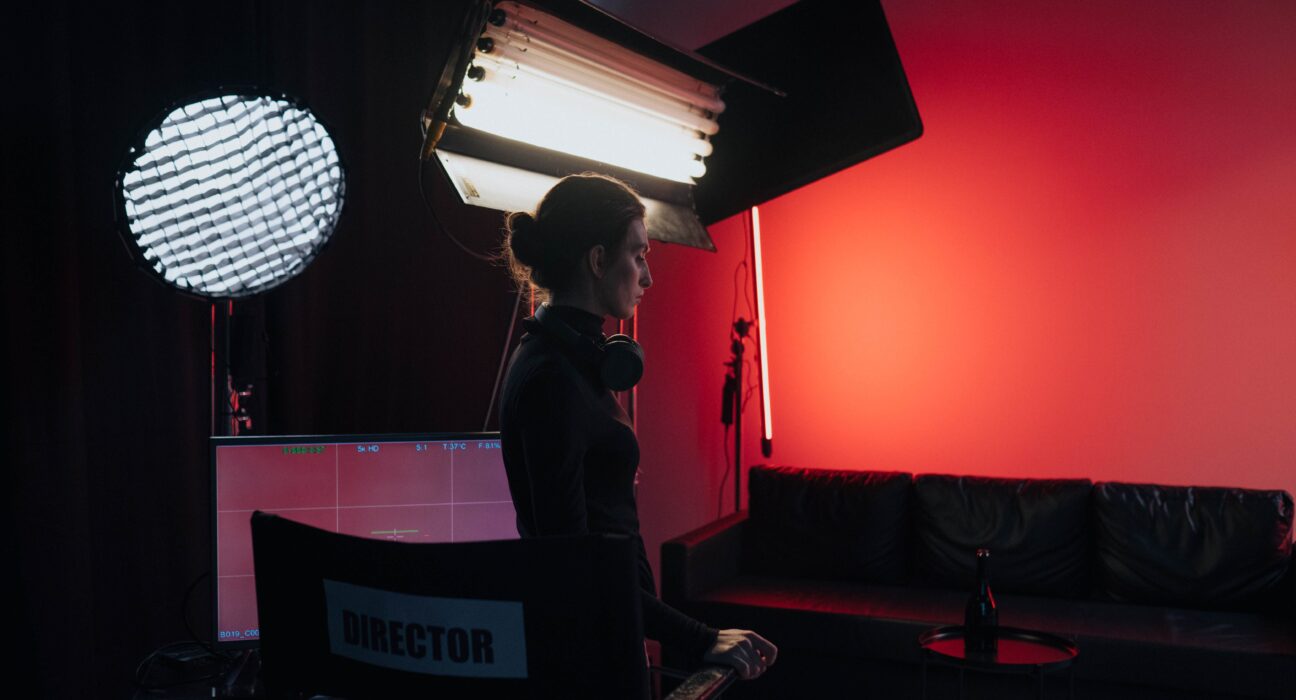 A film director standing in a studio in front of a director's chair, evoking the career behind Rob Reiner net worth