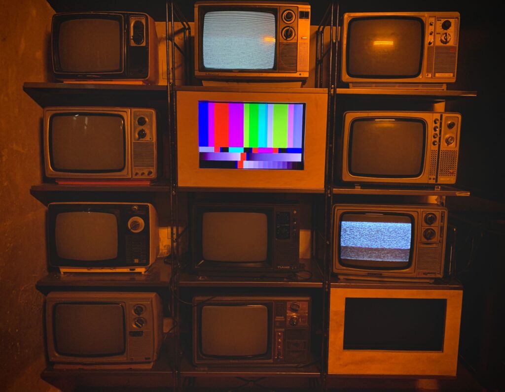 Collection of vintage 1970s televisions with static, recalling the All in the Family era of Rob Reiner net worth